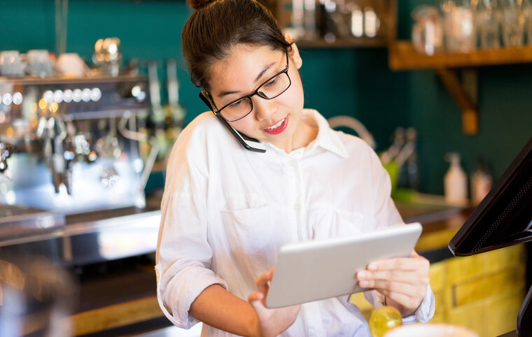 serveerster die naar tablet kijkt - restaurantreservaties verhogen
