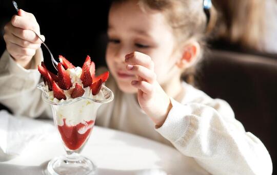 Criança a comer gelado de morango