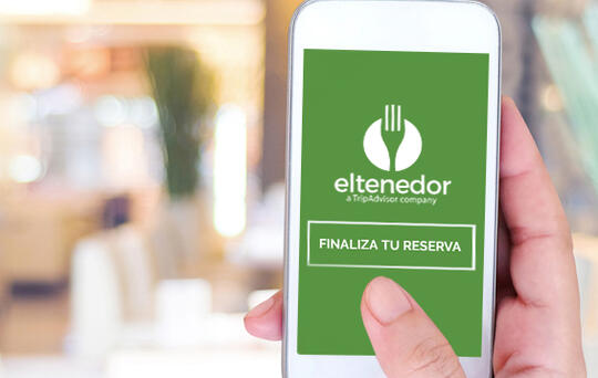 ElTenedor mano con movil mostrando sistema de reservas online restaurantes