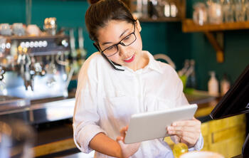 waitress looking at tablet - increase restaurant bookings