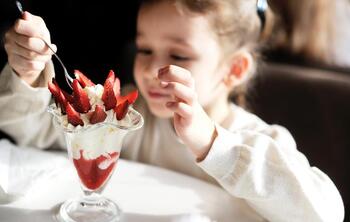 Criança a comer gelado de morango