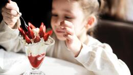 Bambino che mangia un gelato alla fragola