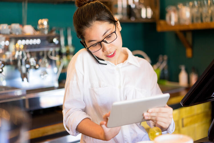 empregada de mesa a olhar para tabler – aumente as reservas no restaurante