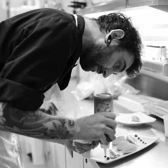 Para captar clientes, los restaurantes rotan sus chefs. En la imagen, un Chef con tatuajes sirve un plato