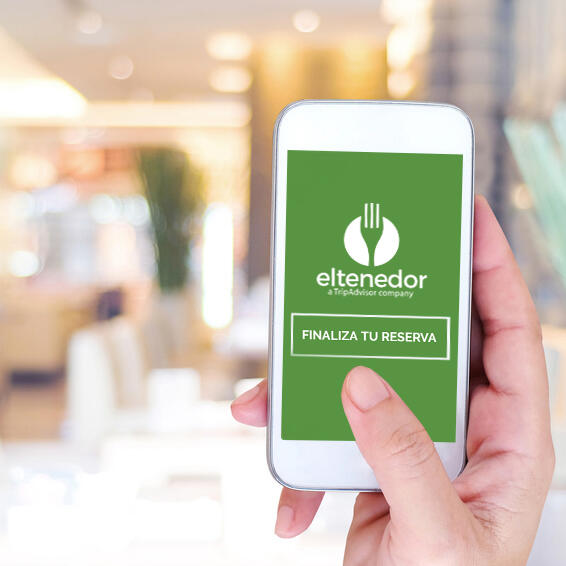 ElTenedor mano con movil mostrando sistema de reservas online restaurantes